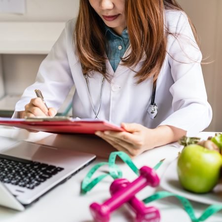 Nutritionist giving consultation to patient with healthy fruit and vegetable